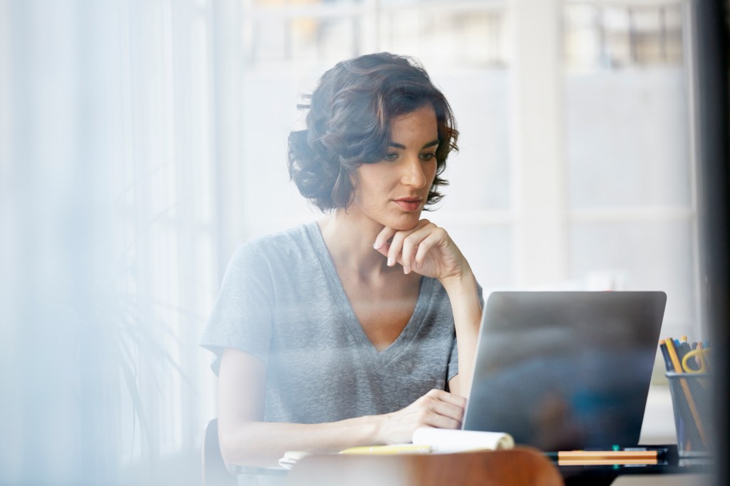 Woman looking at laptop in an office